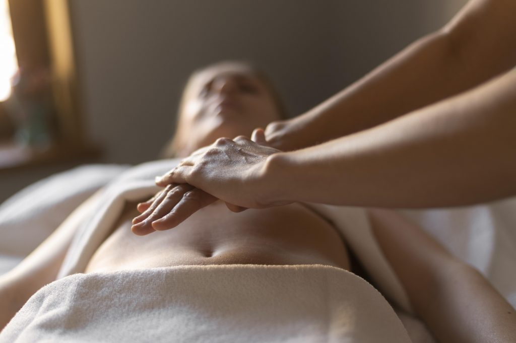 Massage hypotenuse, vue de mains posées en douceur sur une personne allongée, c'est un massage de l'institut Hypotenuse
